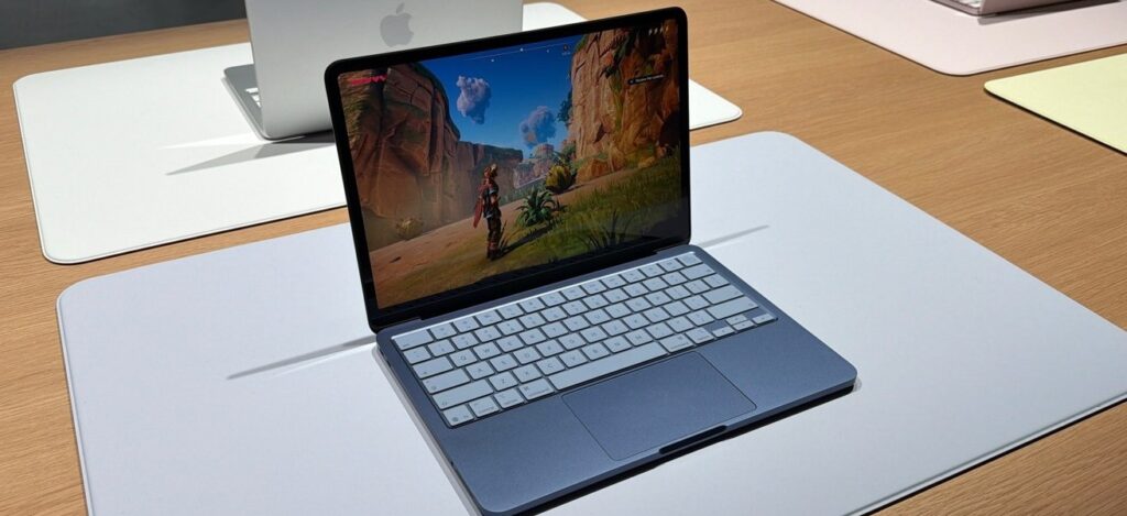 Macbook neo, playing a video game, on a table. 